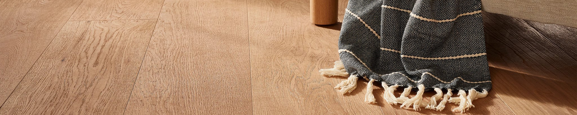 hardwood floor with edge of blanket on furniture